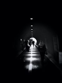 People walking in illuminated corridor