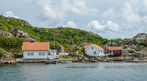 Houses by sea against sky