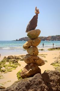 Stack of pebbles on beach against clear sky