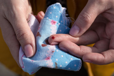 Blood on a woman's finger. a woman's hand wipes blood from a wound with a handkerchief.