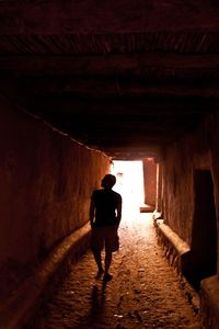 Rear view of woman standing in tunnel