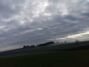 Scenic view of field against cloudy sky