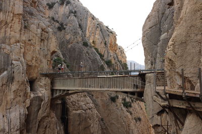 Low angle view of bridge connecting mountain