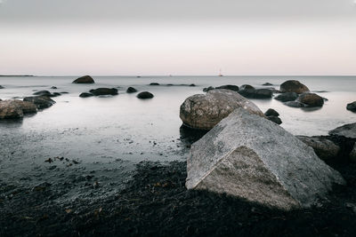 Rocks on sea shore against sky