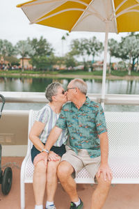 Senior couple kissing while sitting outdoors