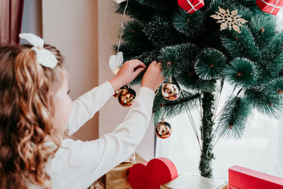 Close-up of girl decorating christmas tree