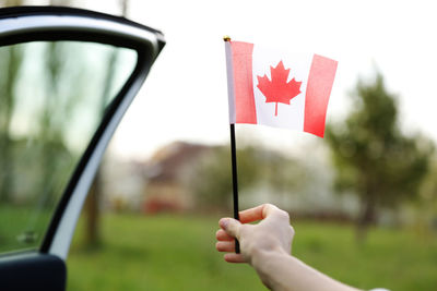 Flag of canada, national symbol waving against, sunny day. canada flag in woman hand. 