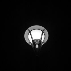 Low angle view of illuminated lamp in darkroom