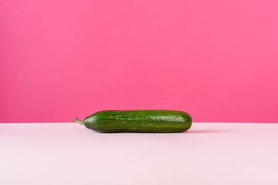 Close-up of green pepper against colored background
