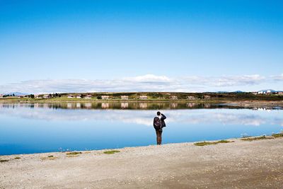 Man standing at calm lake