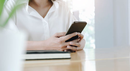 Midsection of woman using mobile phone