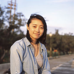 Portrait of smiling young woman against sky during sunset