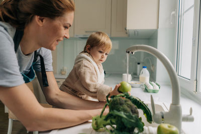 Side view of mother and daughter sitting at home