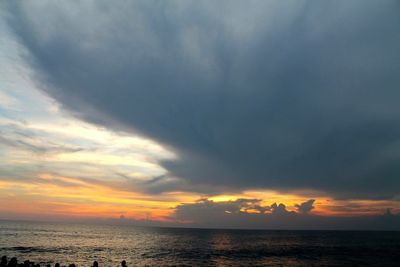 Scenic view of sea against cloudy sky at sunset