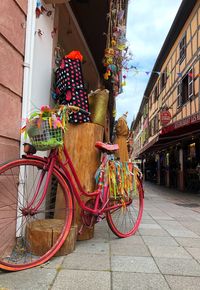 Bicycle parked on footpath against building