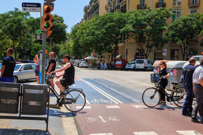 People riding bicycle on road in city