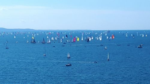 People on beach against clear blue sky