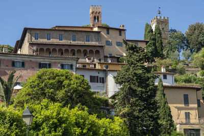 Low angle view of trees and buildings against sky