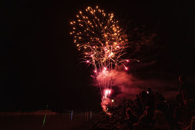 Low angle view of firework display at night