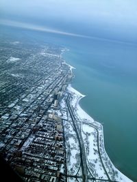 Aerial view of snow covered city by sea