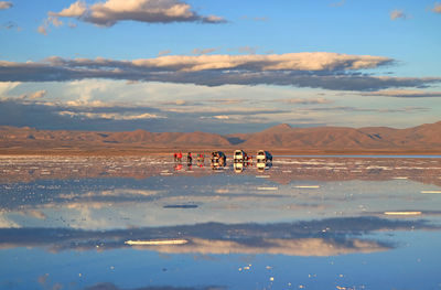 People enjoy the activities on the mirror effect of salar de uyuni salt flats, bolivia