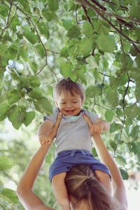 Portrait of cute girl and plants against trees