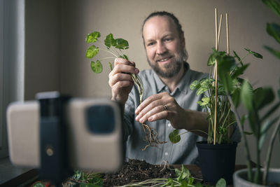 Man vlogging about potted plants