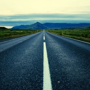 Road leading towards mountains against sky