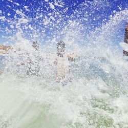 Water splashing in sea against sky