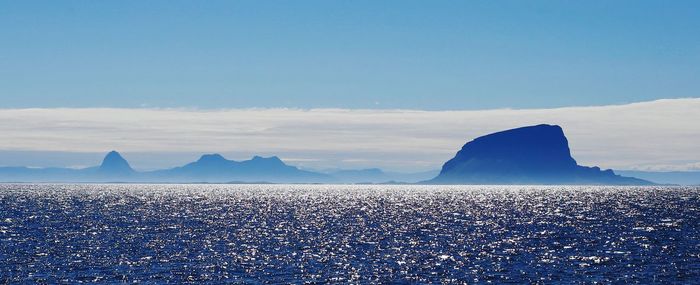 Scenic view of sea and mountains against sky