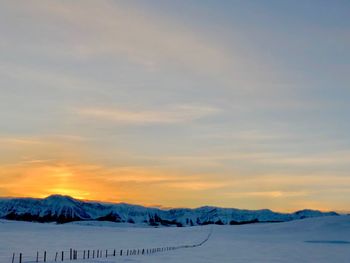 Scenic view of snow mountains against sky during sunset