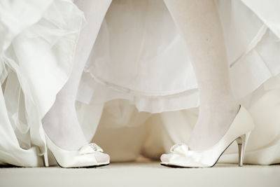 Low section of woman standing on white floor