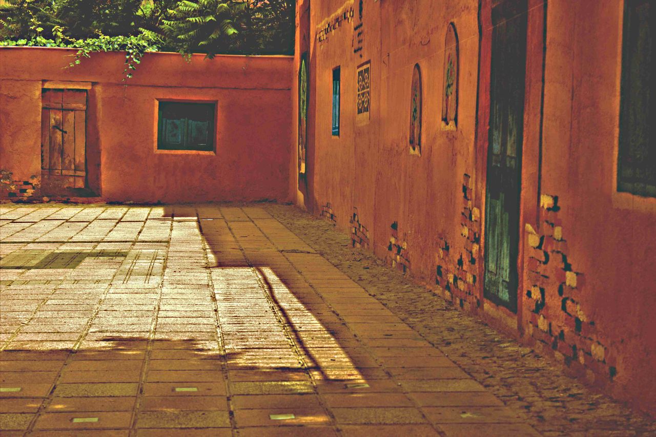 building exterior, built structure, architecture, cobblestone, paving stone, brick wall, wall - building feature, street, the way forward, sidewalk, footpath, outdoors, day, pavement, house, walkway, no people, wall, sunlight, pathway