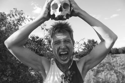 Portrait of smiling young man against sky