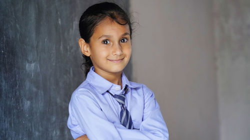 Portrait of boy standing against wall