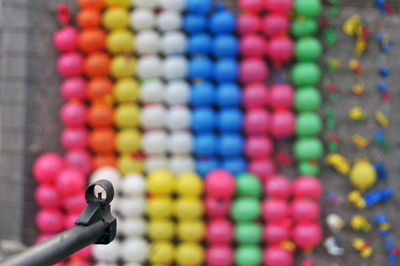 Close-up of weapon against multi colored balloons