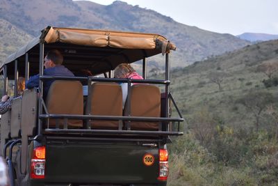 Rear view of people on road against mountain