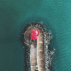 High angle view of lighthouse on pier amidst sea