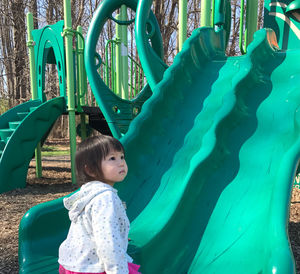 Cute girl playing on slide at playground