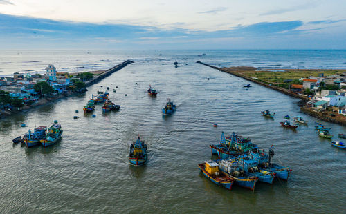 High angle view of people on boats in sea against sky