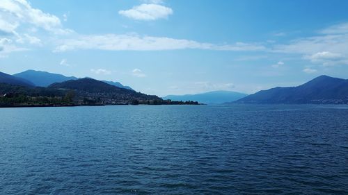 Scenic view of sea by mountains against sky