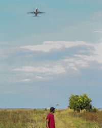 Man flying over agricultural field against sky