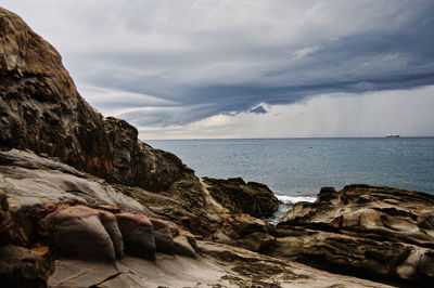 Rock formations on sea shore against sky