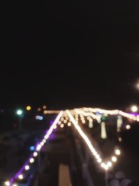 Defocused image of illuminated city against sky at night