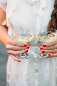 Midsection of woman holding wineglasses