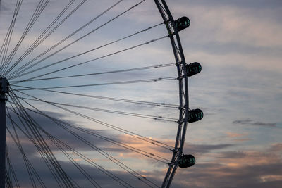 Low angle view of electricity pylon against sky during sunset