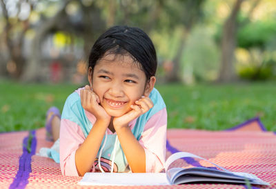 Portrait of smiling girl sitting on book