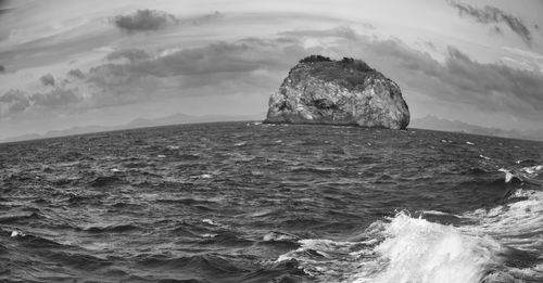 Rocks in sea against sky