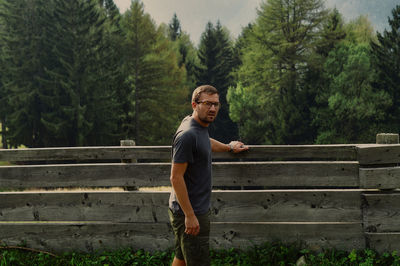 Full length of man standing on bench against trees