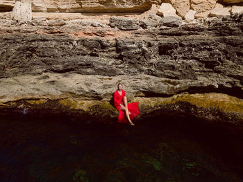 Rear view of woman standing on rock